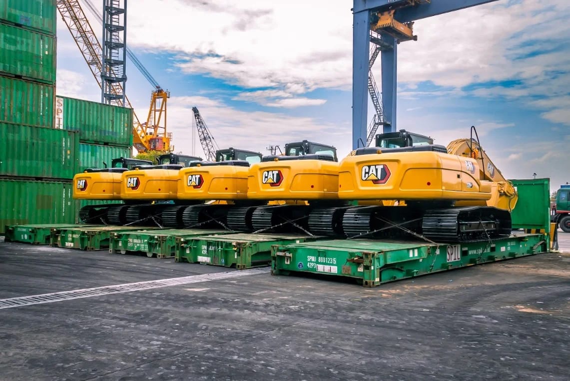Heavy machinery loaded on flatrack containers at port