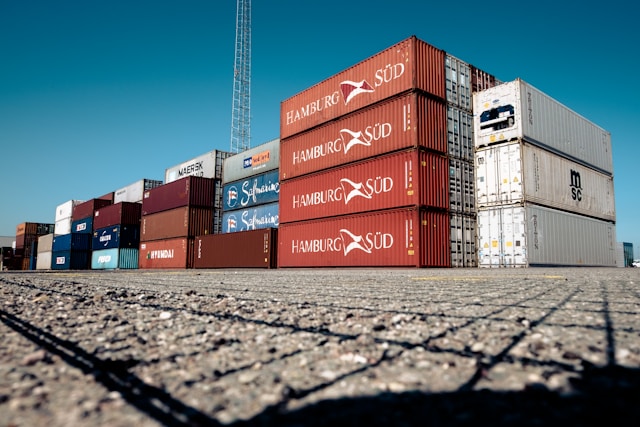 Tumpukan kontainer pengiriman kargo FCL dan LCL di depo pelabuhan logistik siap muat.